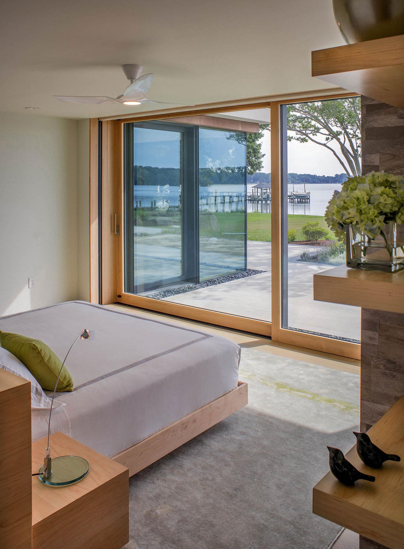 Bedroom with full length windows overlooking the water
